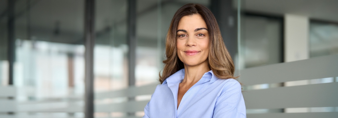 middle-aged successful woman looking directly at the camera exuding confidence with a closed mouth smile and intelligent eyes