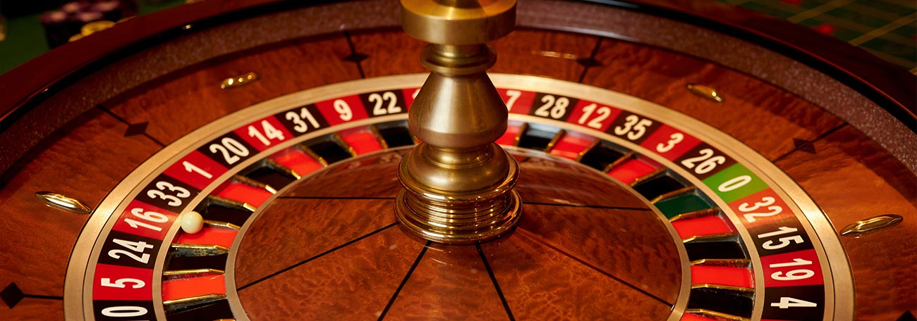 a beautiful roulette wheel in red and black with reddish-brown hardwood finish