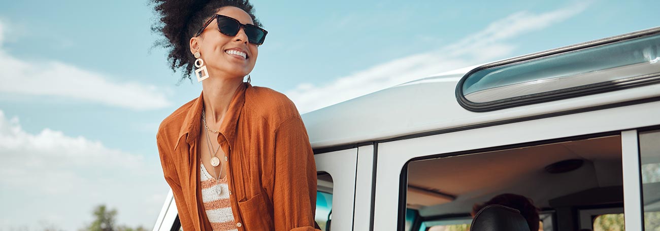 woman enjoying the air hanging outside the window of a car on a roadtrip