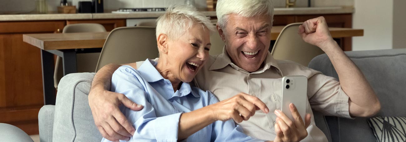 smiling senior couple enjoying something online